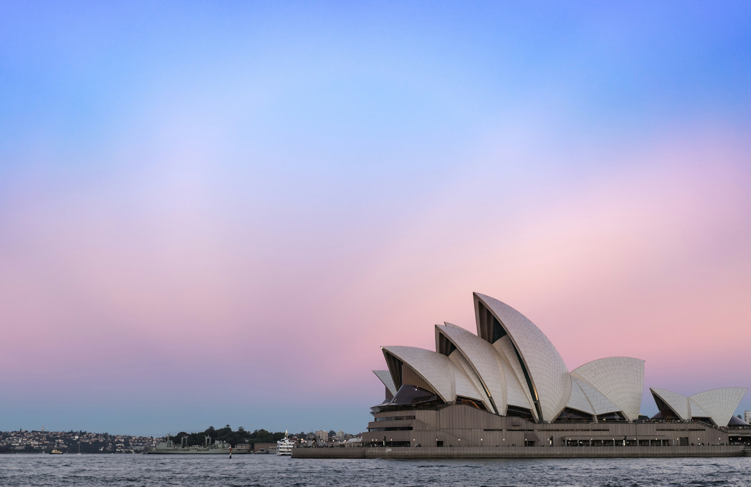 The Sydney Opera House and the harbor at dusk